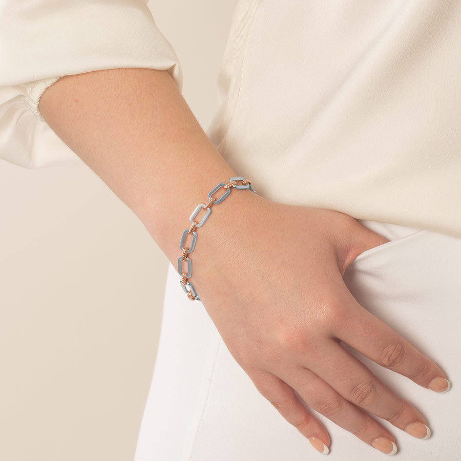 Woman wearing silver tone oval link medical alert bracelet with 14k rose gold plated accents.