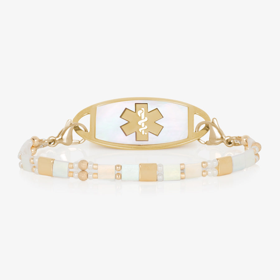 White and gold beaded stretch medical ID bracelet paired with gold tone stainless steel medical ID tag with mother of pearl inlay and gold tone medical symbol.