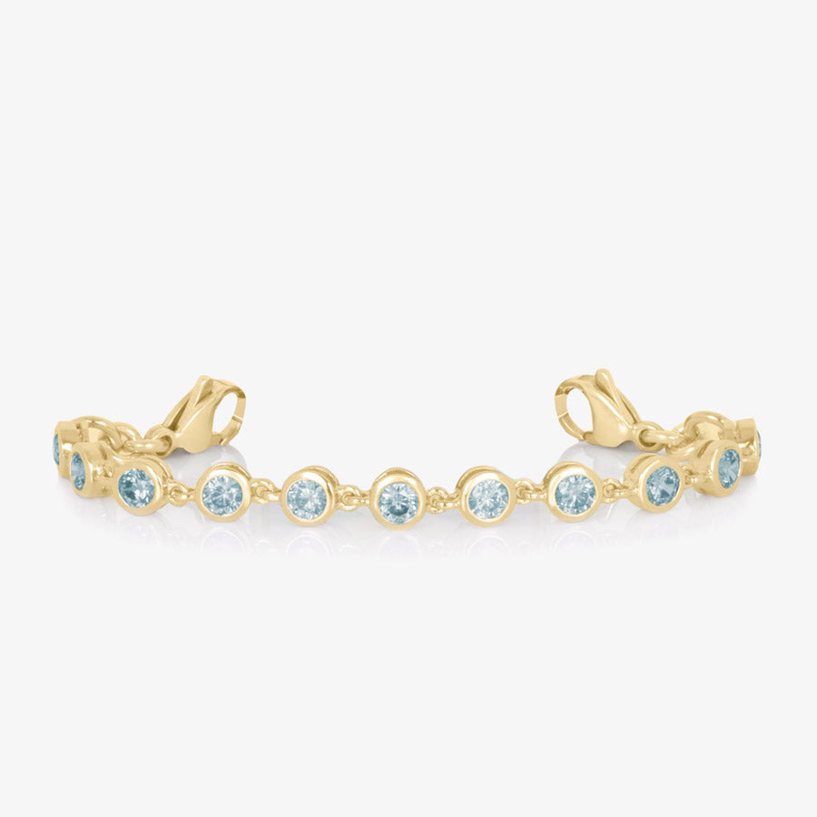 12k gold plated tennis bracelet with individually linked, round, aquamarine cubic zirconias.