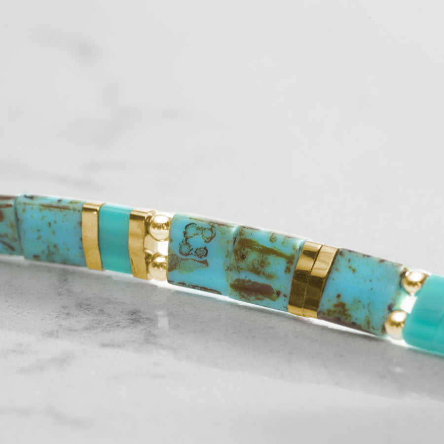 Close up image of turquoise tila beads.