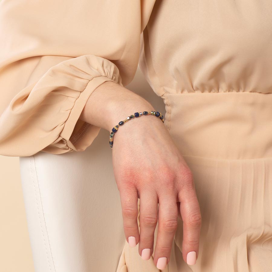 Woman wearing blue and gold beaded bracelet