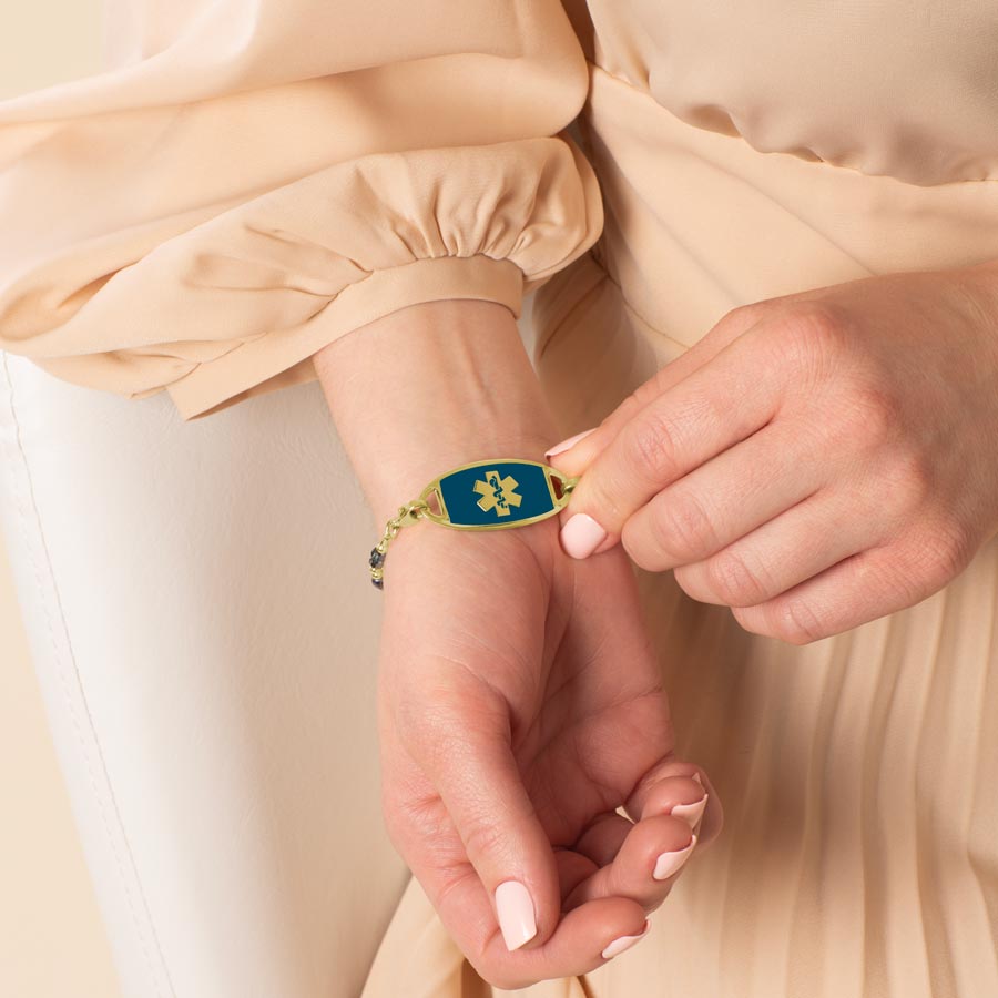 Woman showing her gold and sapphire medical Id Tag