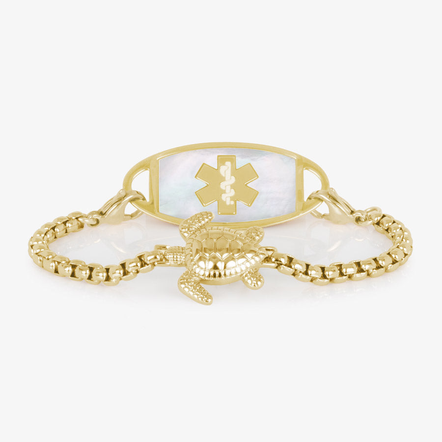 Gold tone box chain bracelet featuring a sea turtle centerpiece, attached to a gold tone medical ID with mother of pearl inlay.