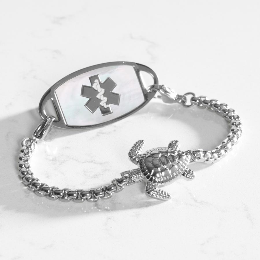 Silver box chain bracelet featuring a sea turtle centerpiece, attached to a stainless steel medical ID with mother of pearl inlay.