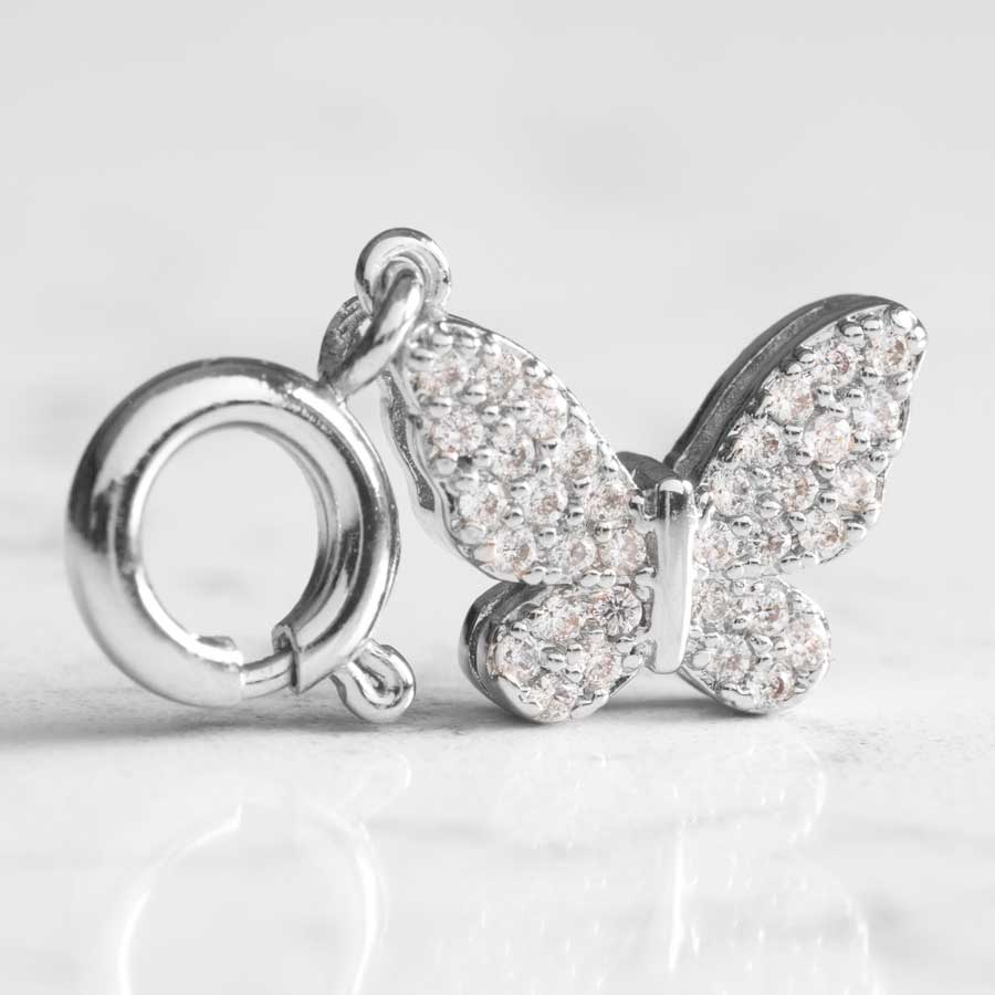 Impressive butterfly shaped charm with sparkling crystals stop a white marble counter