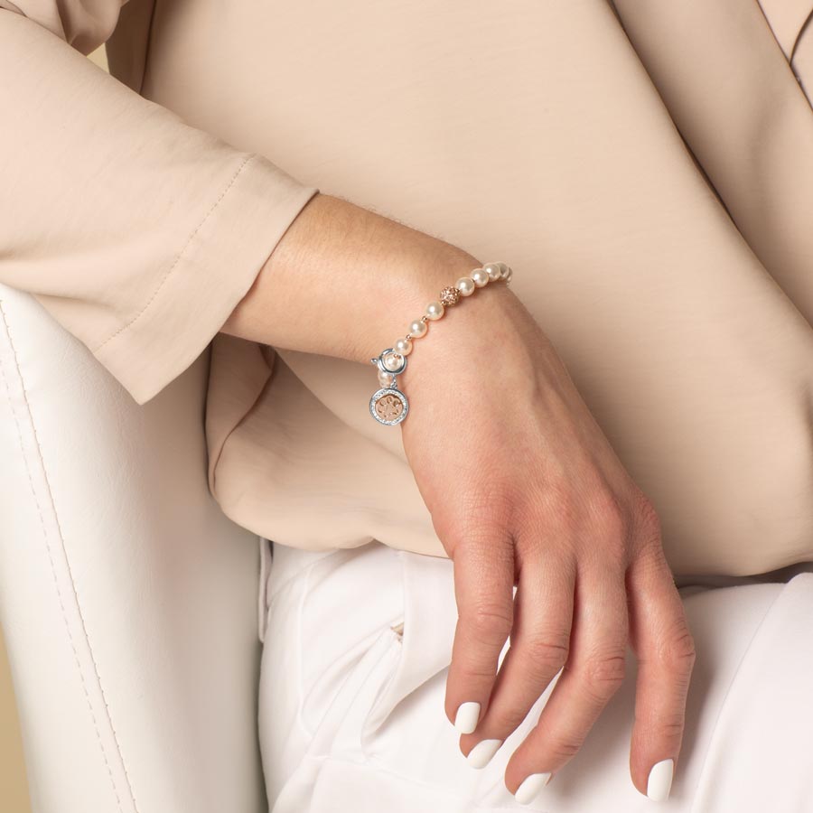 Elegant woman wearing a silver bracelet with silver and rose gold paw cut out charm attached