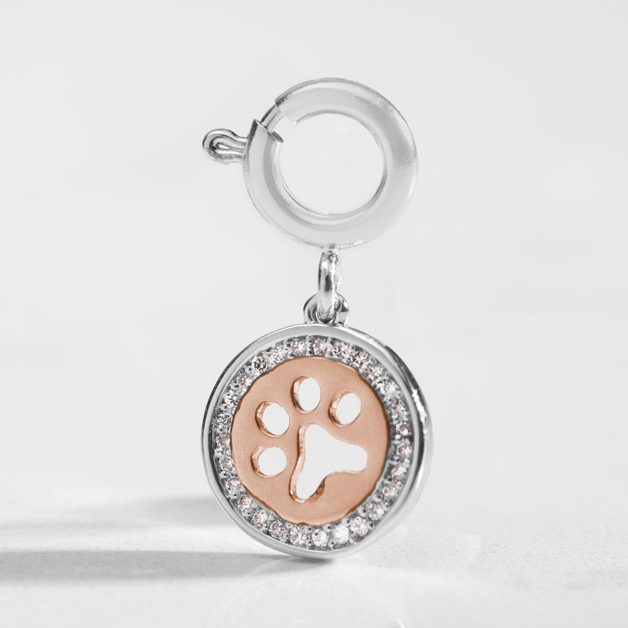 Detail shot of silver and Rose Gold paw cut out charm