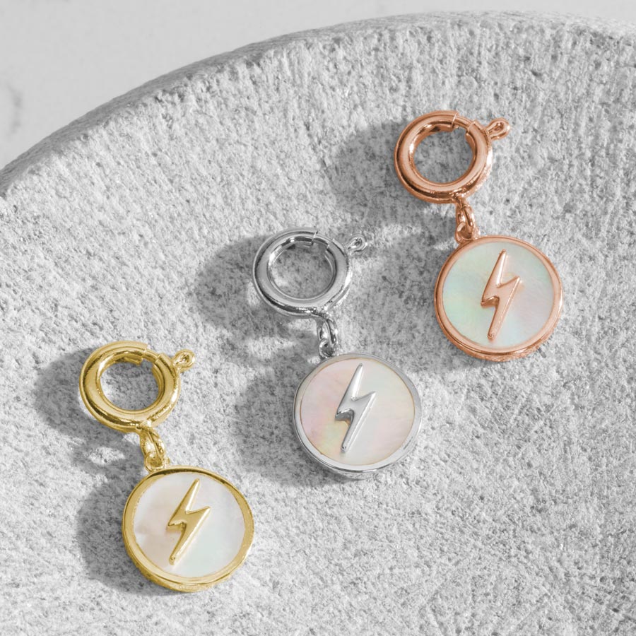 3 round charms, featuring a mother of pearl inlay with lightning bolt in silver, rose and gold.