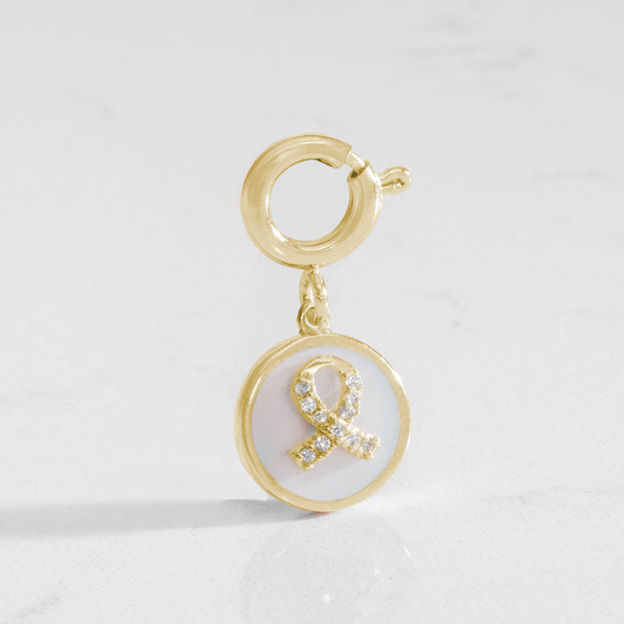 Gold tone round charm with mother of pearl inlay and gold awareness ribbon with inset crystals