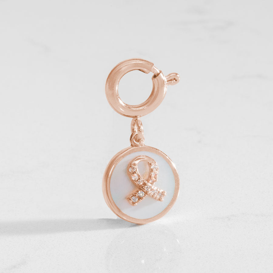 Rose gold tone round charm with mother of pearl inlay and rose gold awareness ribbon with inset crystals