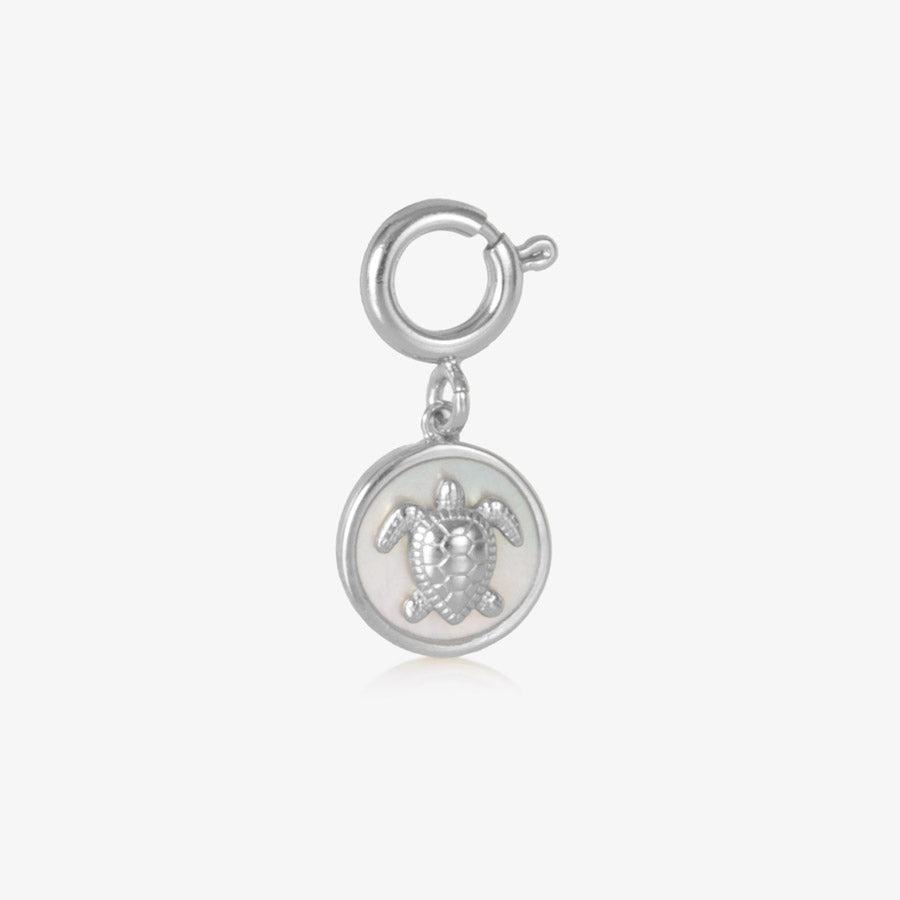 Round, silver charm featuring a silver sea turtle on inlaid mother of pearl.