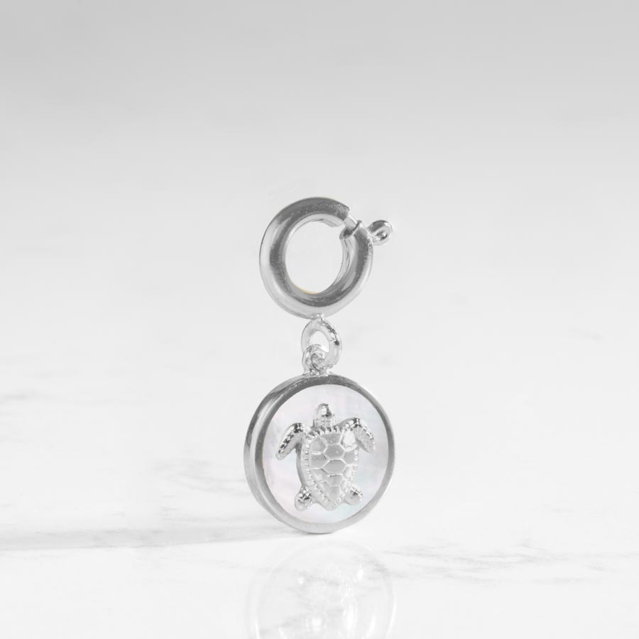 Round, silver charm, with inlaid mother of pearl and silver sea turtle