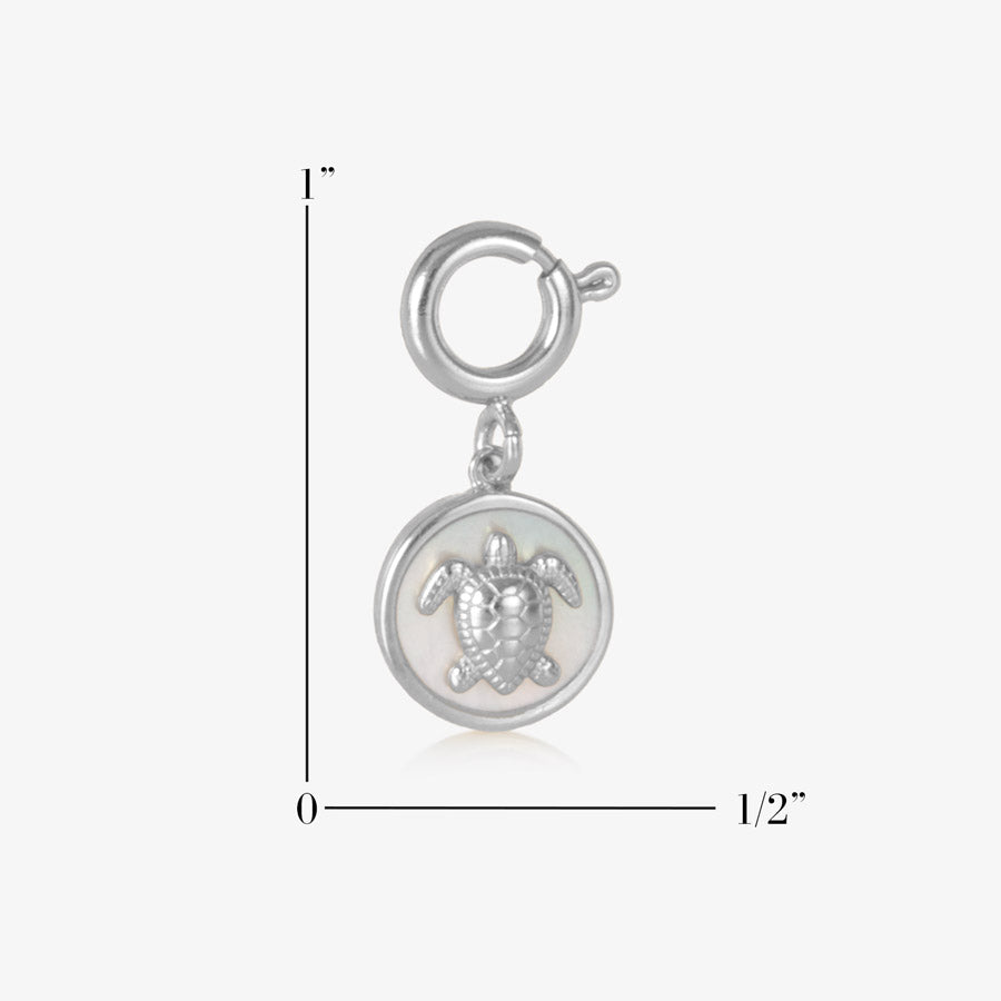 Round, silver charm featuring a silver sea turtle on inlaid mother of pearl. Measurements of 1 inch by one half inch