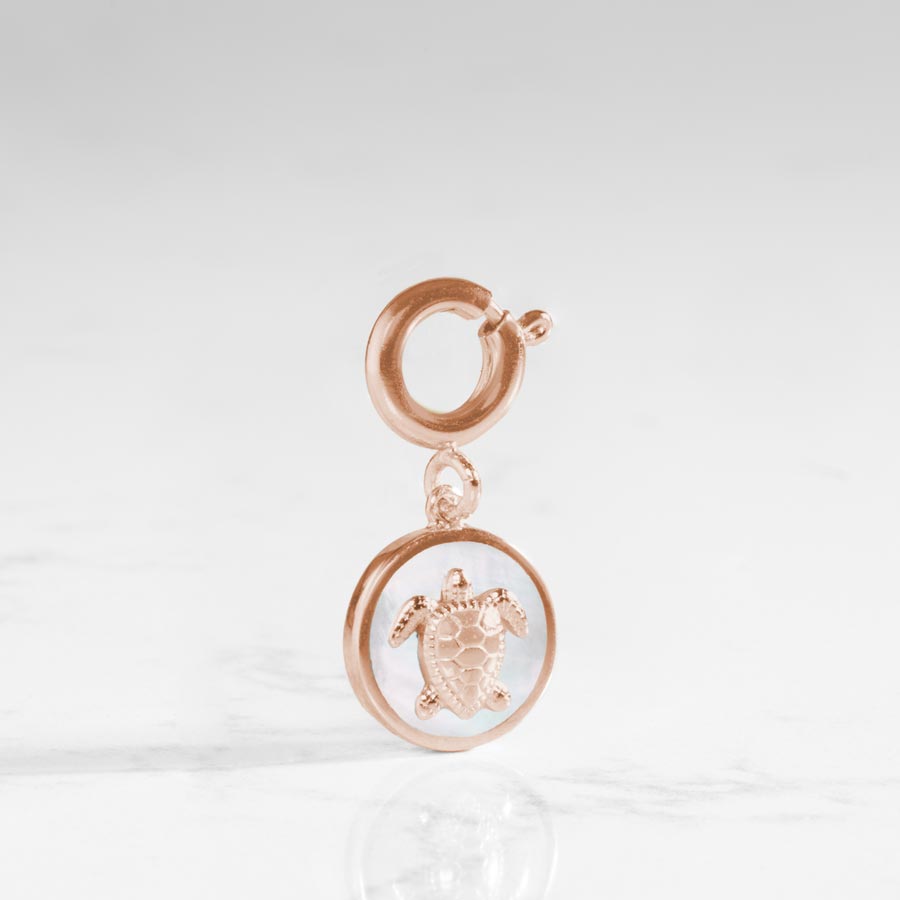 Round, sea turtle charm in rose gold featuring a mother of pearl inlay.