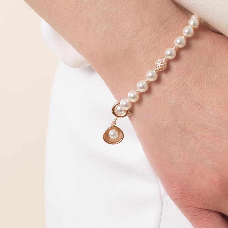 Woman wearing 14k rose gold plated open oyster shell charm featuring a single, lustrous pearl