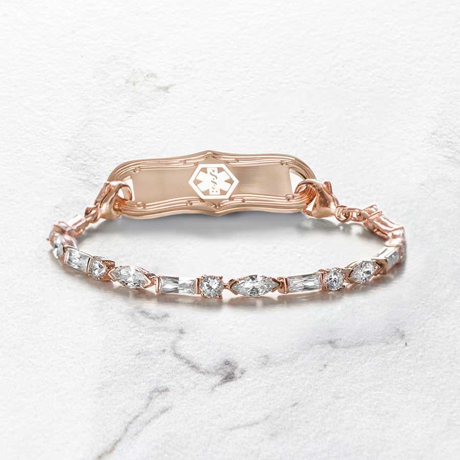 Rose gold tone medical ID bracelet with round, rectangle, and oval clear cubic zirconia crystals paired with rose gold tone med ID tag with mother of pearl inlay and rose gold medical symbol.