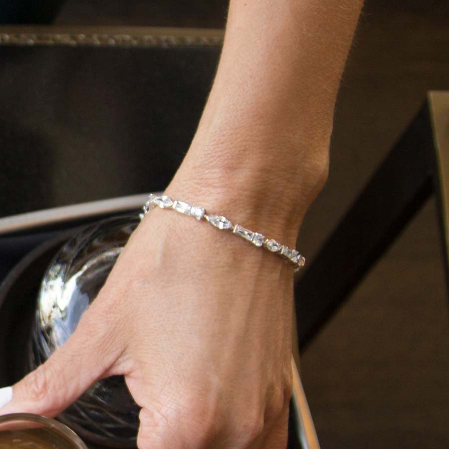 Woman wearing Cantata Medical ID Bracelet in Sterling silver with 3 shapes cubic zirconia and La Petite tag, white caduceus