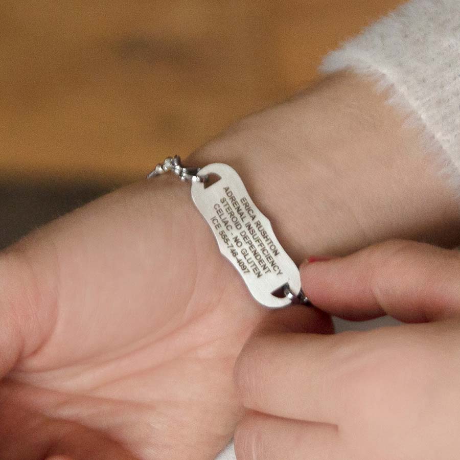 Woman showing custom laser engraved medical alert tag