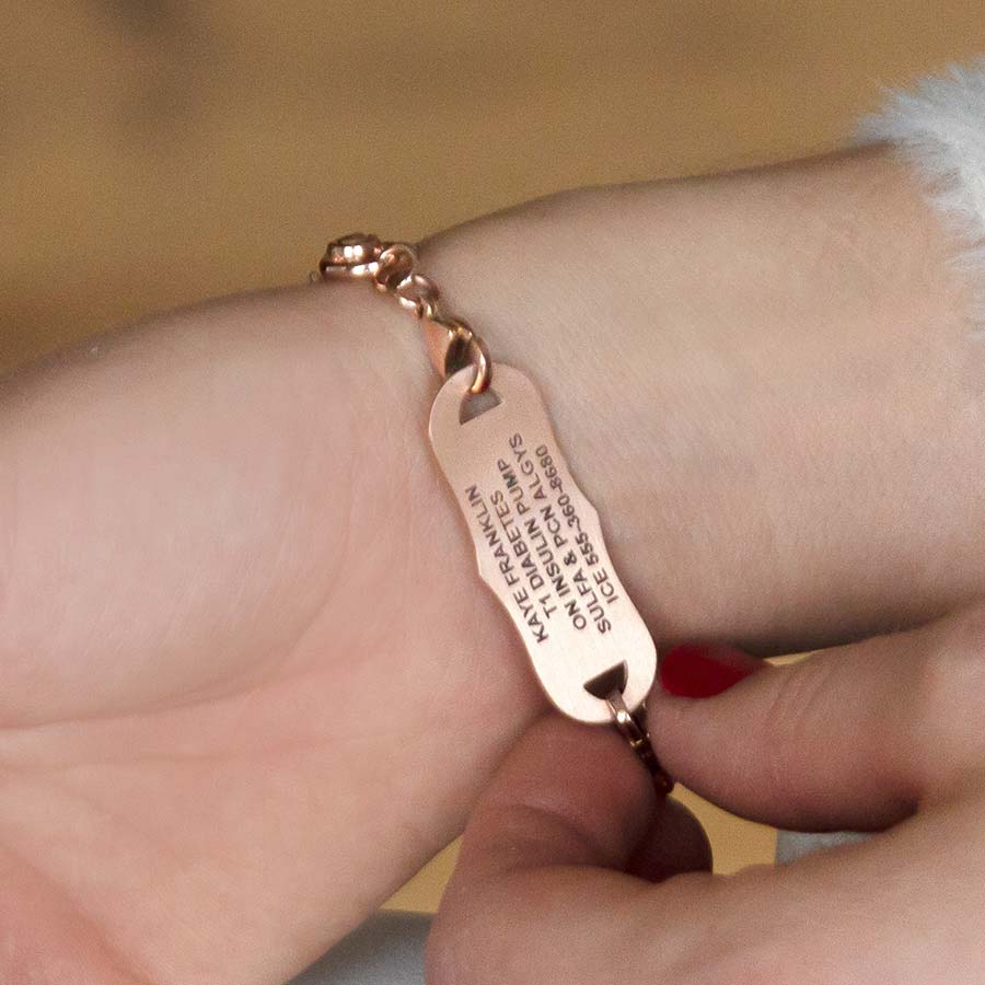 Woman showing custom laser engraved medical alert tag