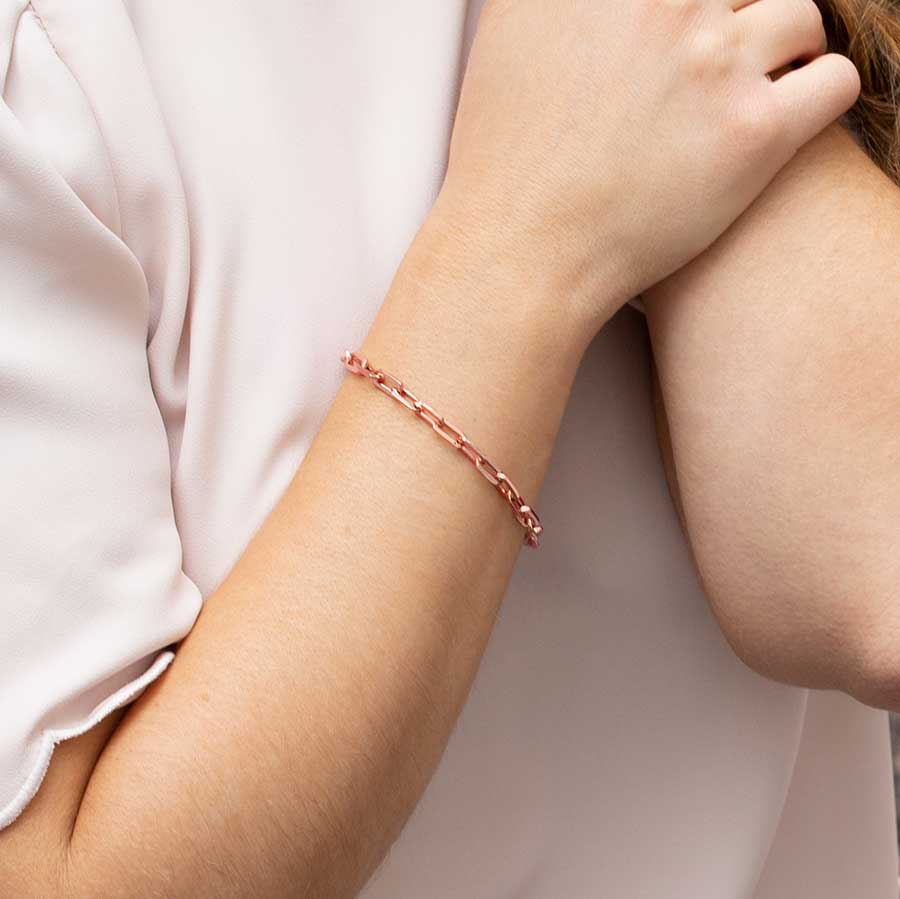 Woman wearing rose gold paperclip medical ID bracelet chain