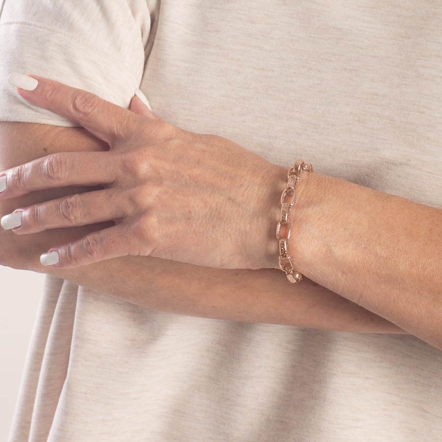 Woman wearing rose gold plated detailed oval link medical ID chain bracelet.