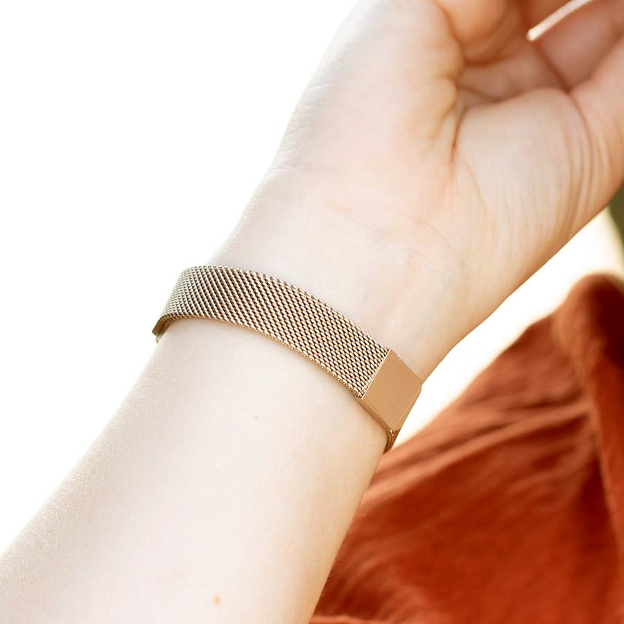 Woman showing mesh chain band with magnetic closure on brushed sandstone stainless Urban Medical Alert bracelet.