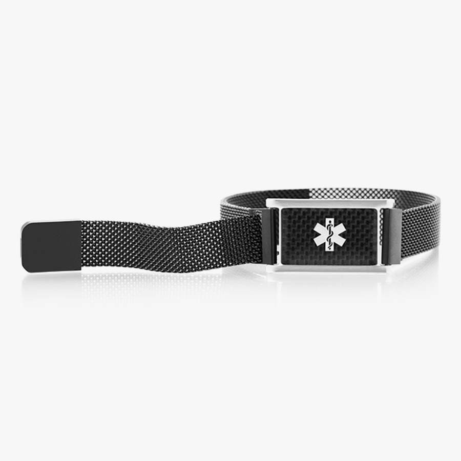 Front of stainless black magnetic bracelet with black mesh chain and affixed medical ID tag with silver caduceus on carbon fiber background