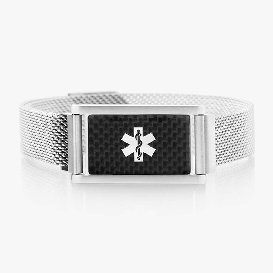 Front of stainless steel magnetic bracelet with silver mesh chain and affixed medical ID tag with silver caduceus on carbon fiber background