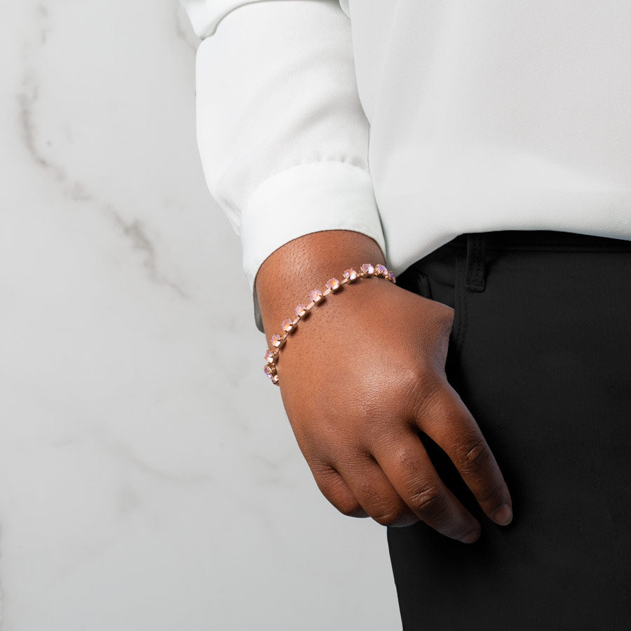 Woman wearing dusty rose cubic zirconia crystals set in a rose gold tone chain.