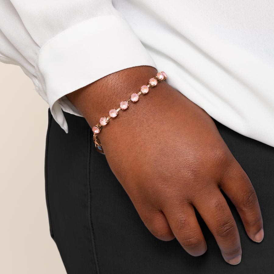 Woman wearing dusty rose cubic zirconia crystals set in a rose gold tone chain.