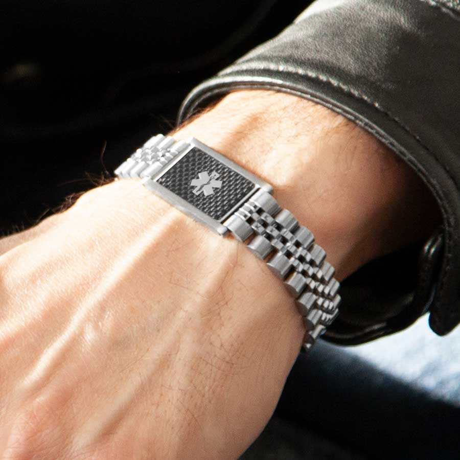 Man wearing silver linked medical ID bracelet with carbon fiber inlay on medical alert tag