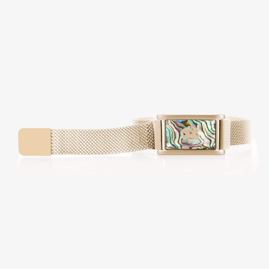 Gold tone stainless steel bracelet with adjustable mesh band and affixed ID tag with abalone inlay and gold tone medical symbol.