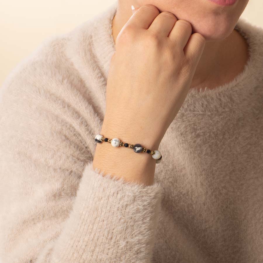 Woman wearing dendritic opal, black crystal, and gold beaded medical ID bracelet.