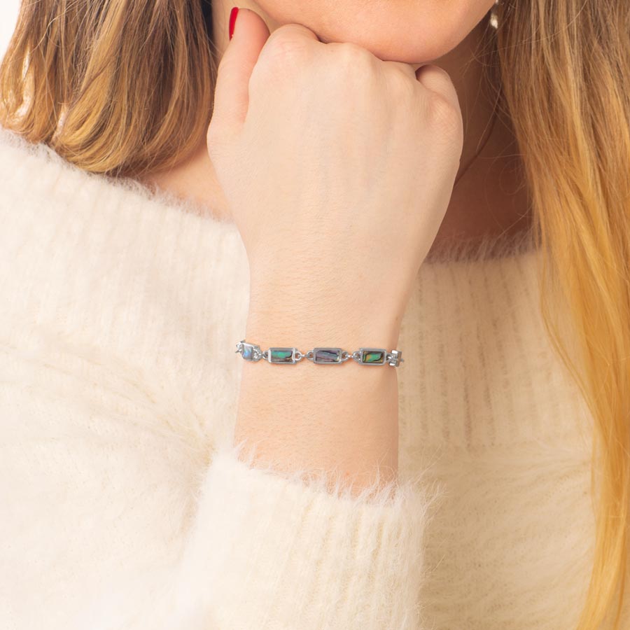 Woman wearing blue and green abalone with silver medical ID chain bracelet