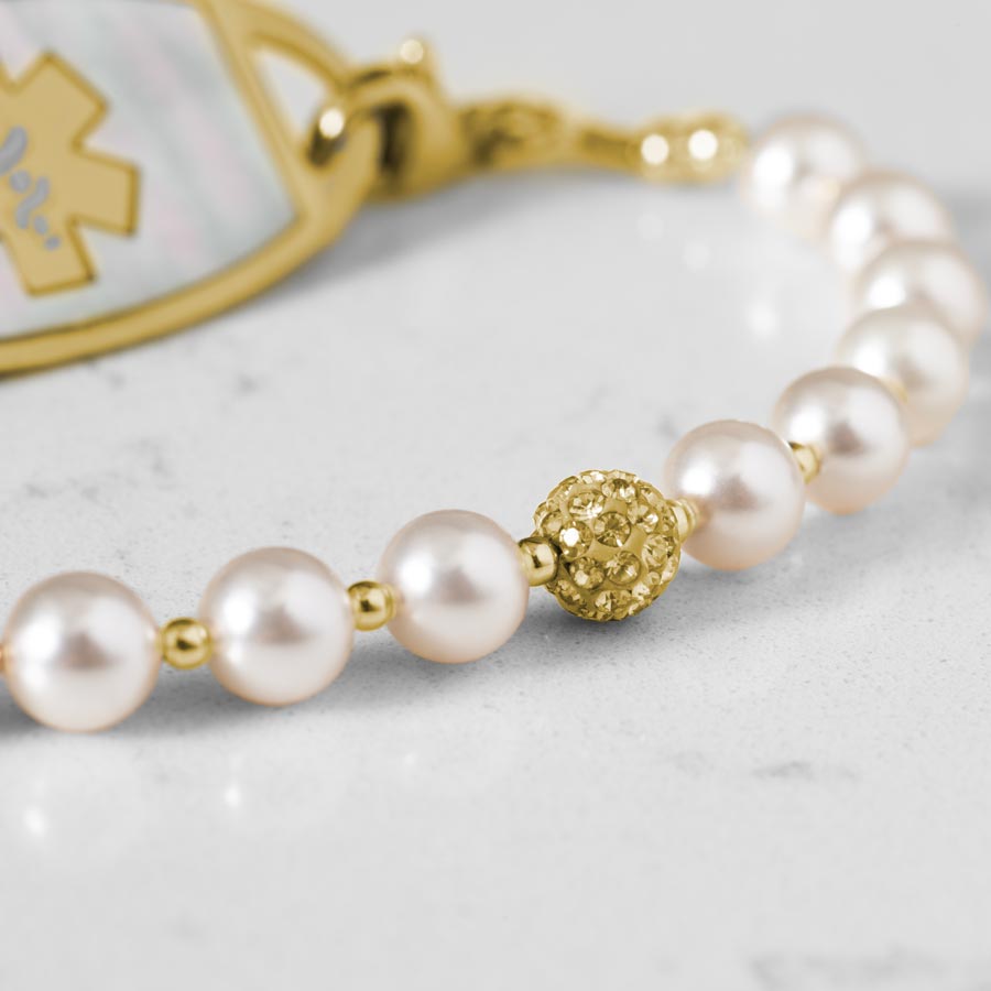 Close up image of pearls and sparkly gold tone centerpiece.