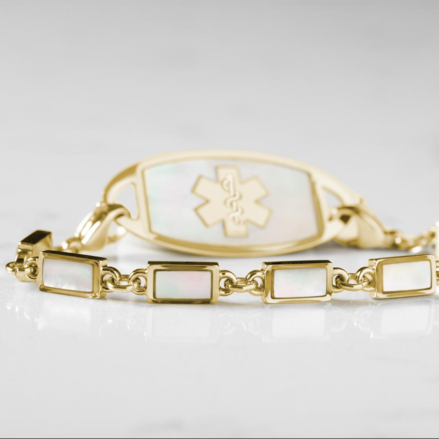 Single strand medical alert bracelet with yellow gold links and mother of pearl inlay and mother of pearl medical ID tag