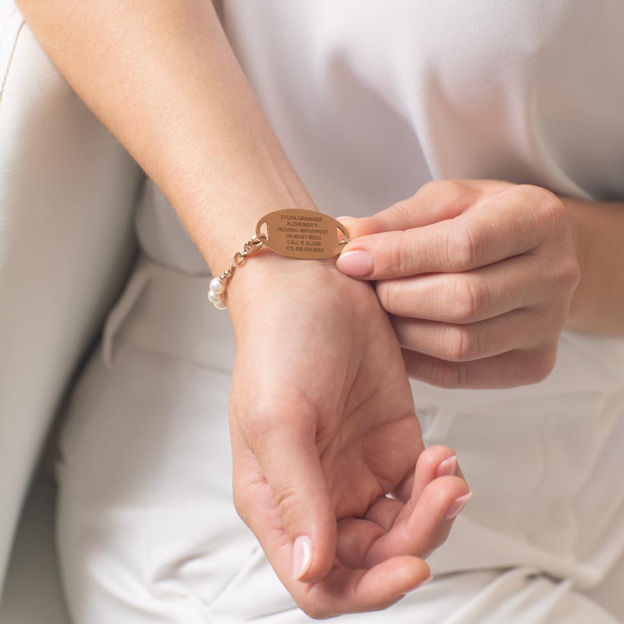 Woman showing custom laser engraved medical ID tag.