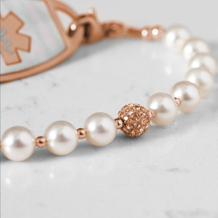 Close up image of pearls and sparkly rose gold tone centerpiece.