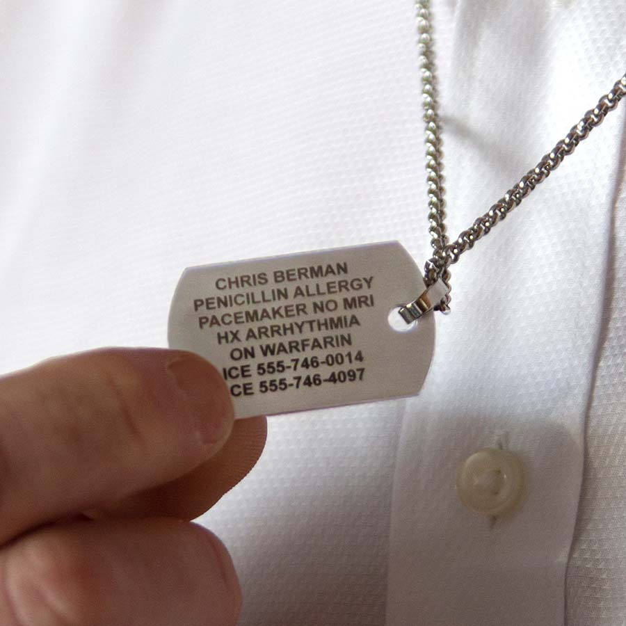 Man showing custom engraved medical ID dog tag necklace with laser engraving