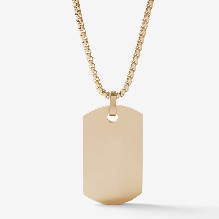 The back side of the gold tone medical ID dog tag necklace with black decorative inlay on a gold tone rolo chain.