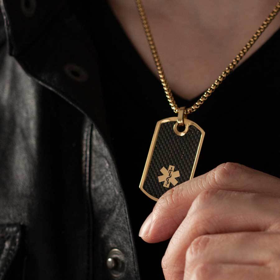 Man wearing gold medical ID alert dog tag necklace with black inlay and gold rolo chain