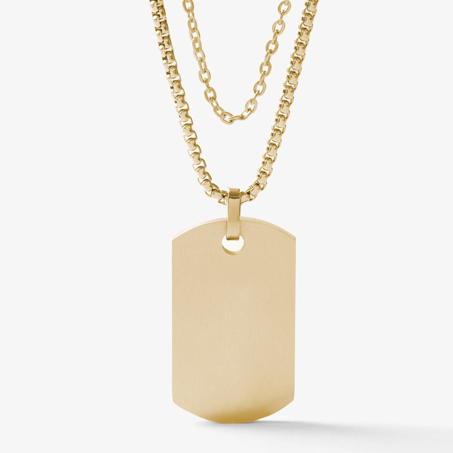 Back side of 14K gold tone medical ID dog tag on a gold tone snake chain layered with gold tone accent chain.