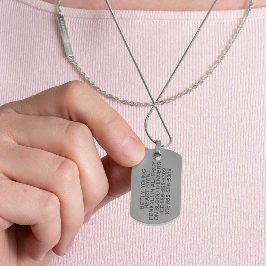 Woman showing custom laser engraved medical ID alert dog tag necklace in silver