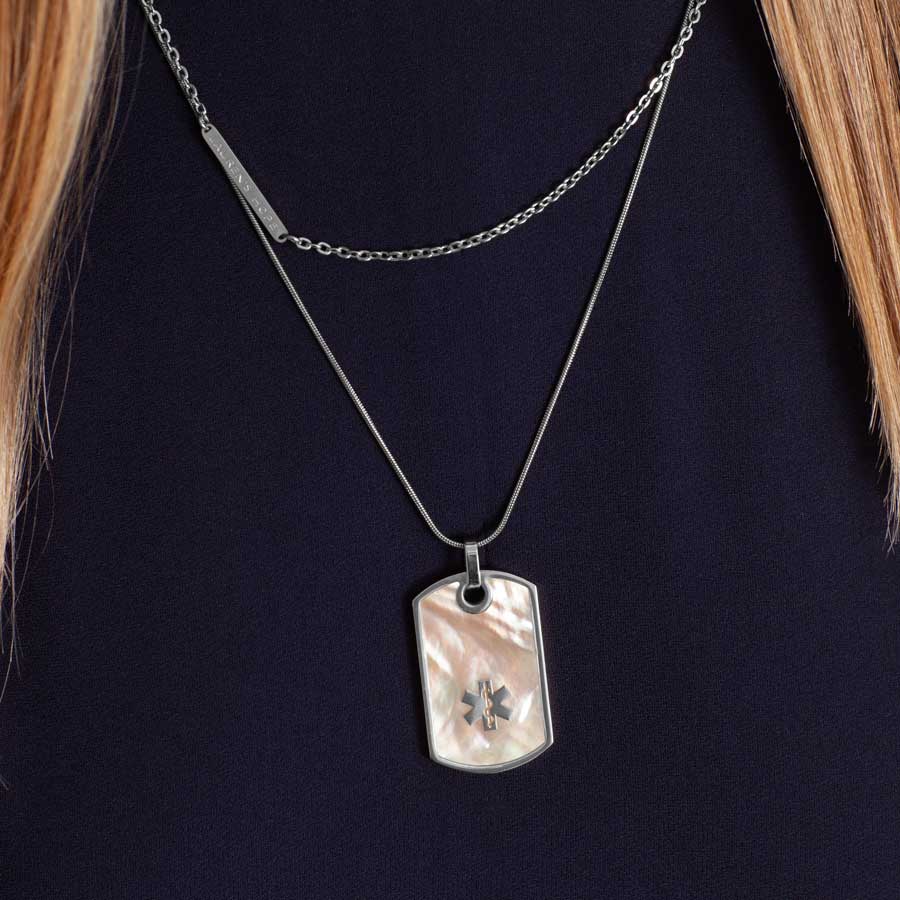 Woman wearing silver and mother of pearl medical ID necklace with layered necklace strand