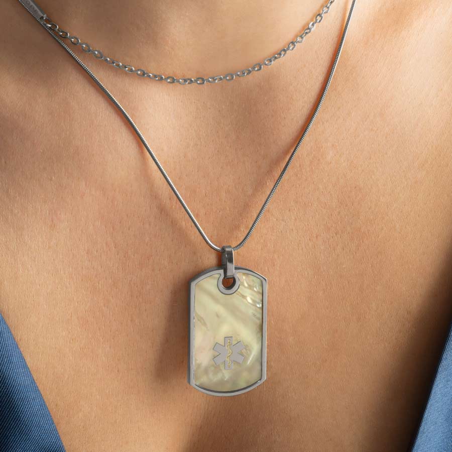 Woman wearing silver and mother of pearl medical ID alert dog tag necklace