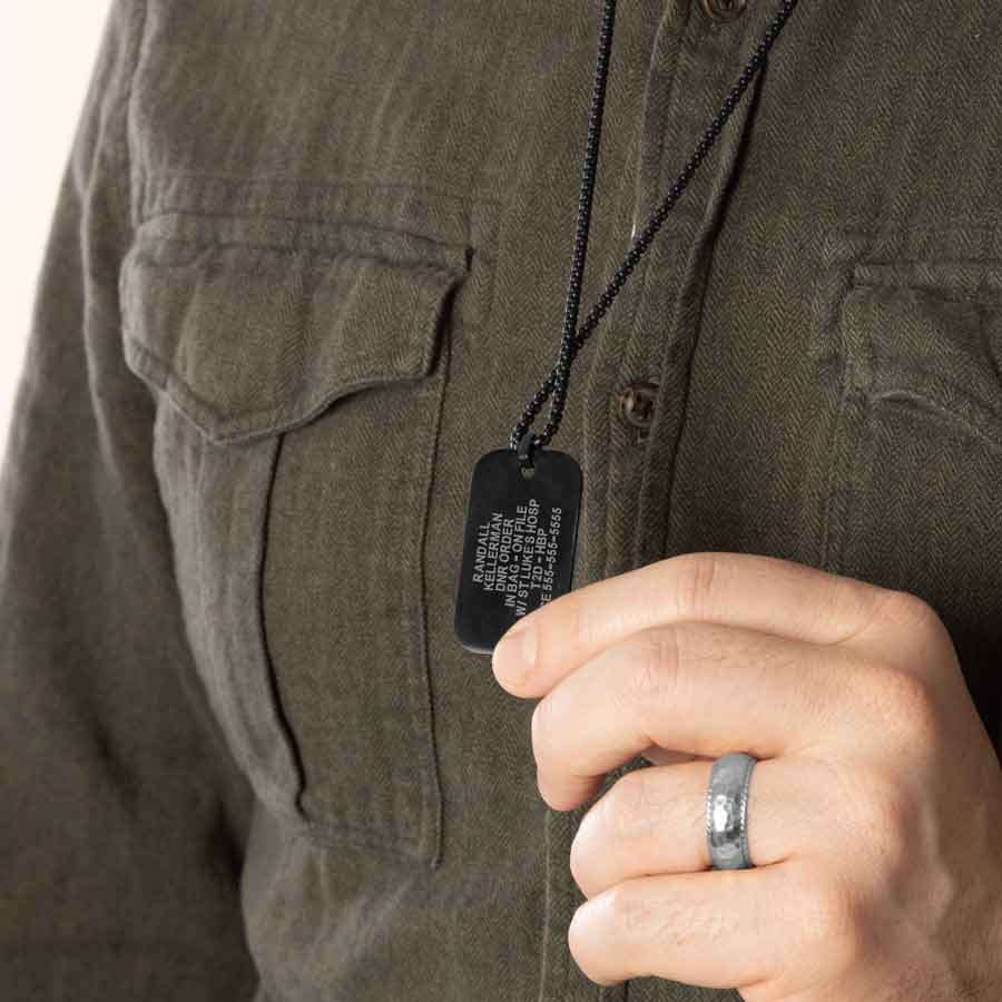 Man showing custom engraved medical ID dog tag necklace with laser engraving