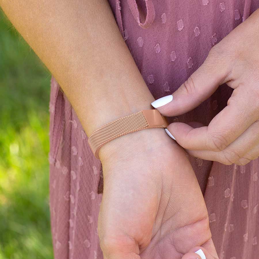 Woman showing magnetic clasp on rose gold medical ID bracelet