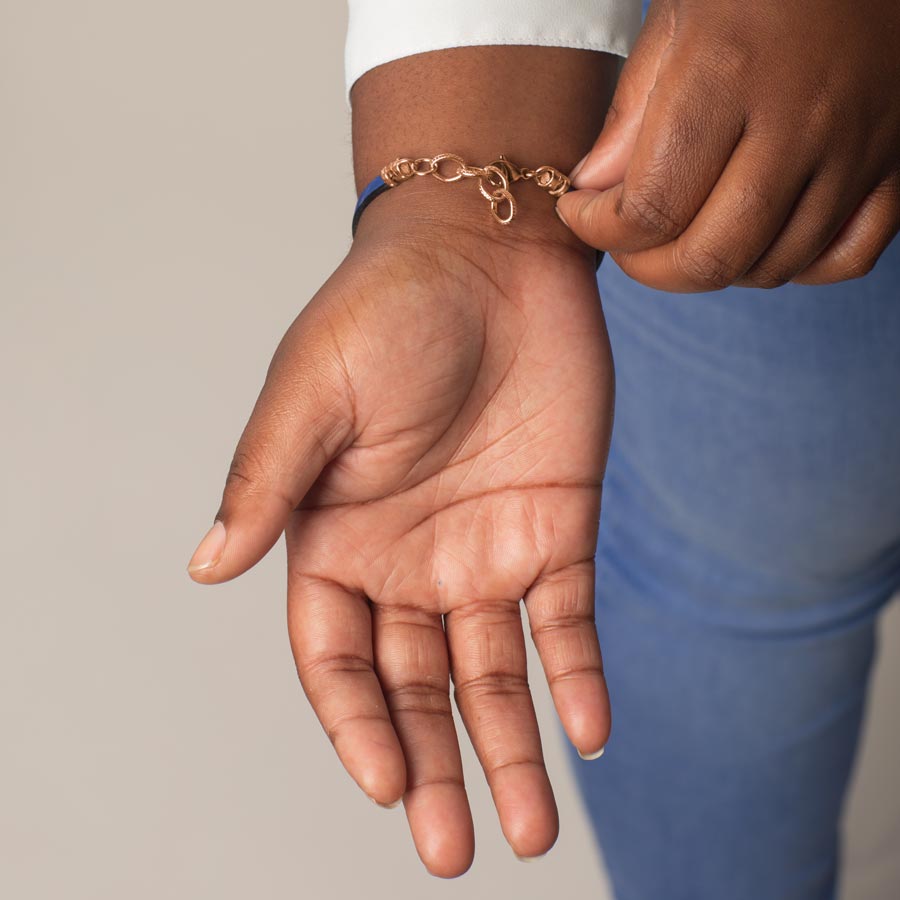 Woman showing rose gold clasp on adjustable rose gold chain