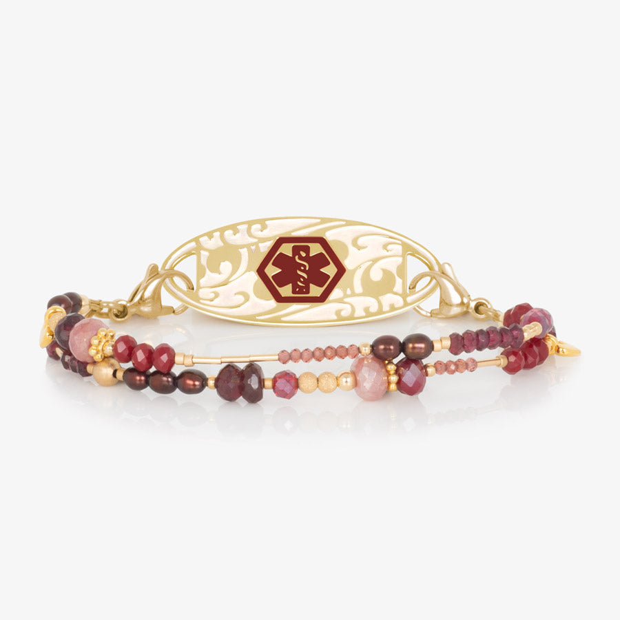 Ruby, garnet, and pink crystal and beaded multi-strand medical ID bracelet paired with gold tone stainless steel medical ID tag with filigree inlay and red medical symbol at the center.