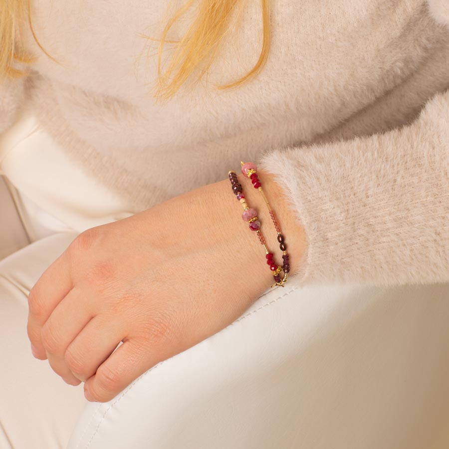 Woman wearing ruby, garnet, and pink crystal and beaded multi-strand medical ID bracelet.